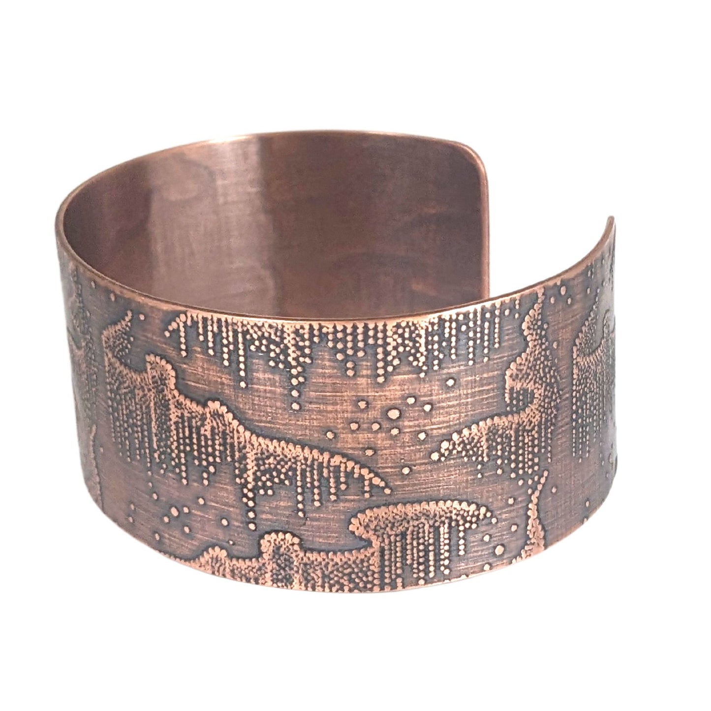 Wide copper cuff bracelet with repeated design pattern representing the aurora borealis