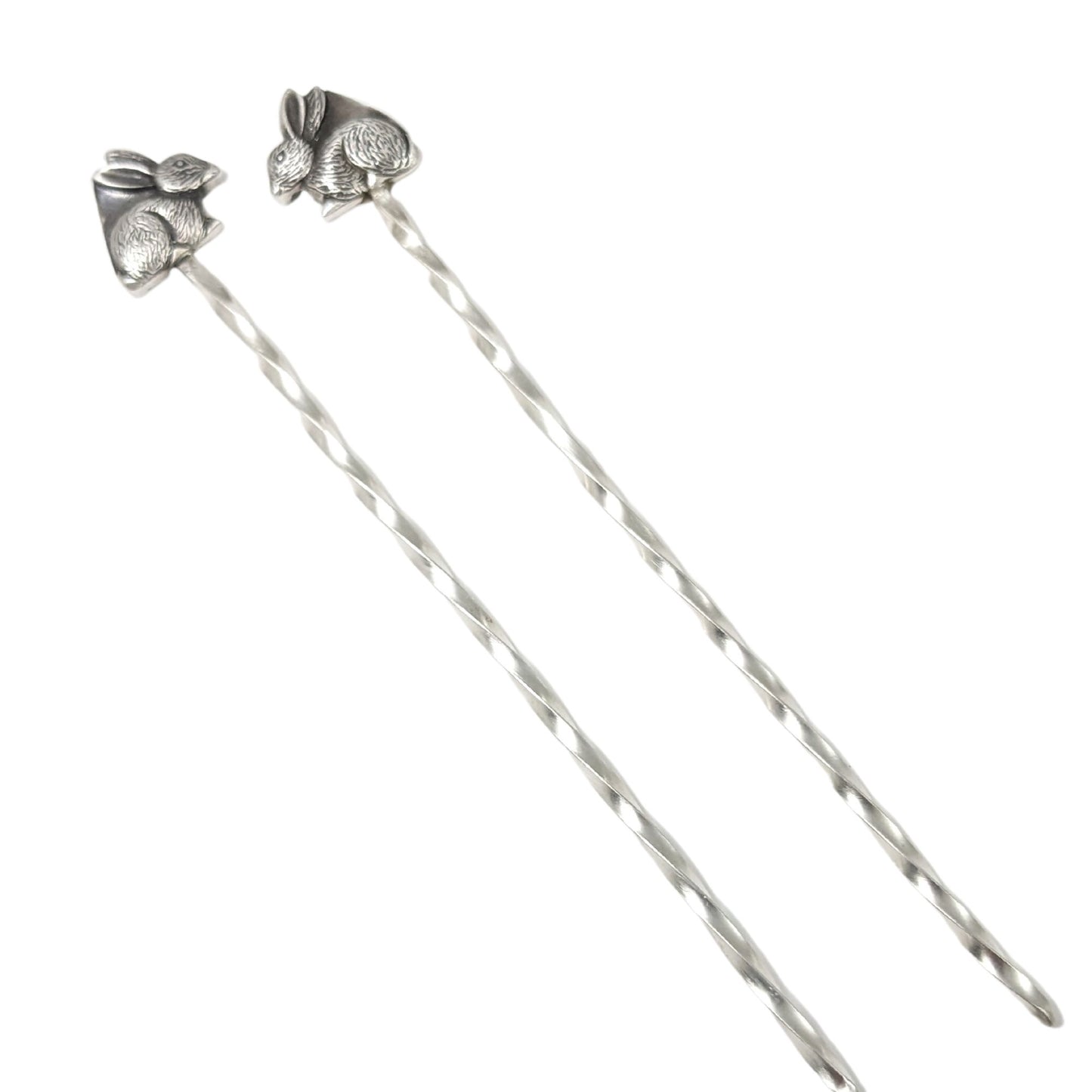 Sterling silver cocktail picks with silver rabbits on top. One rabbit faces left, the other faces right.