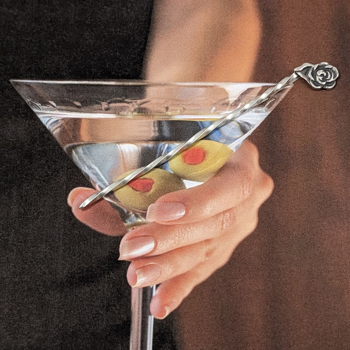 Sterling silver cocktail pick with a rose on top.