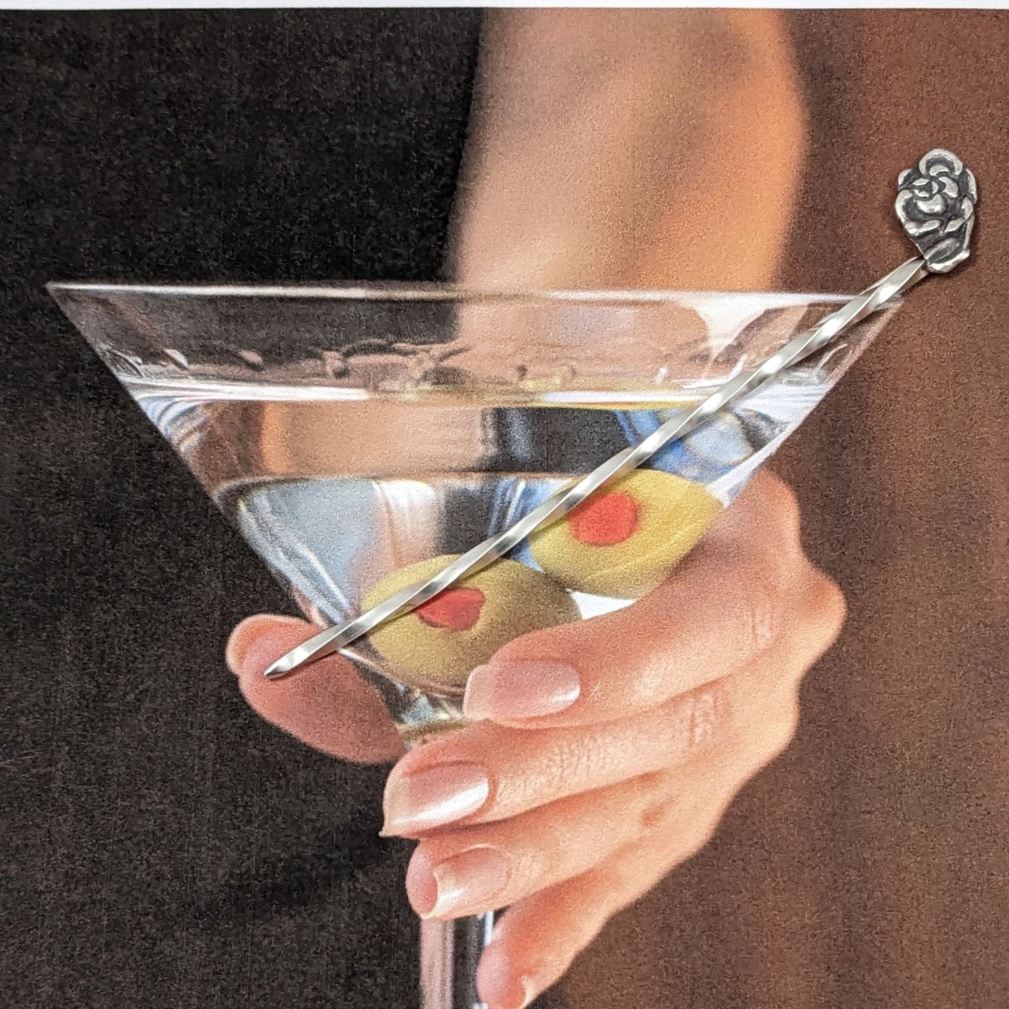 Sterling silver cocktail pick with a rose on top.