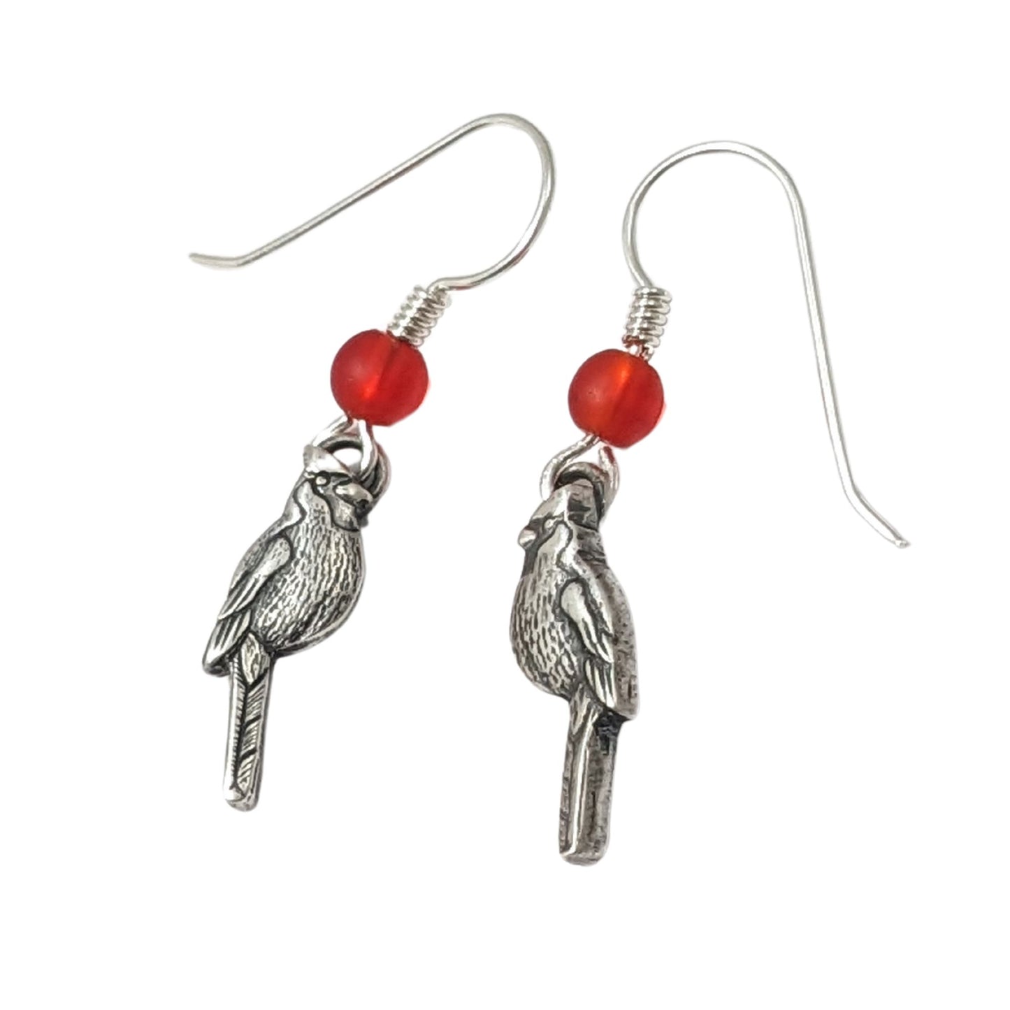 Cardinal birds as sterling silver earrings. There is one left facing Cardinal and one right facing cardinal. Above the Cardinals, attached to the ear wire, is a red Czech glass bead.