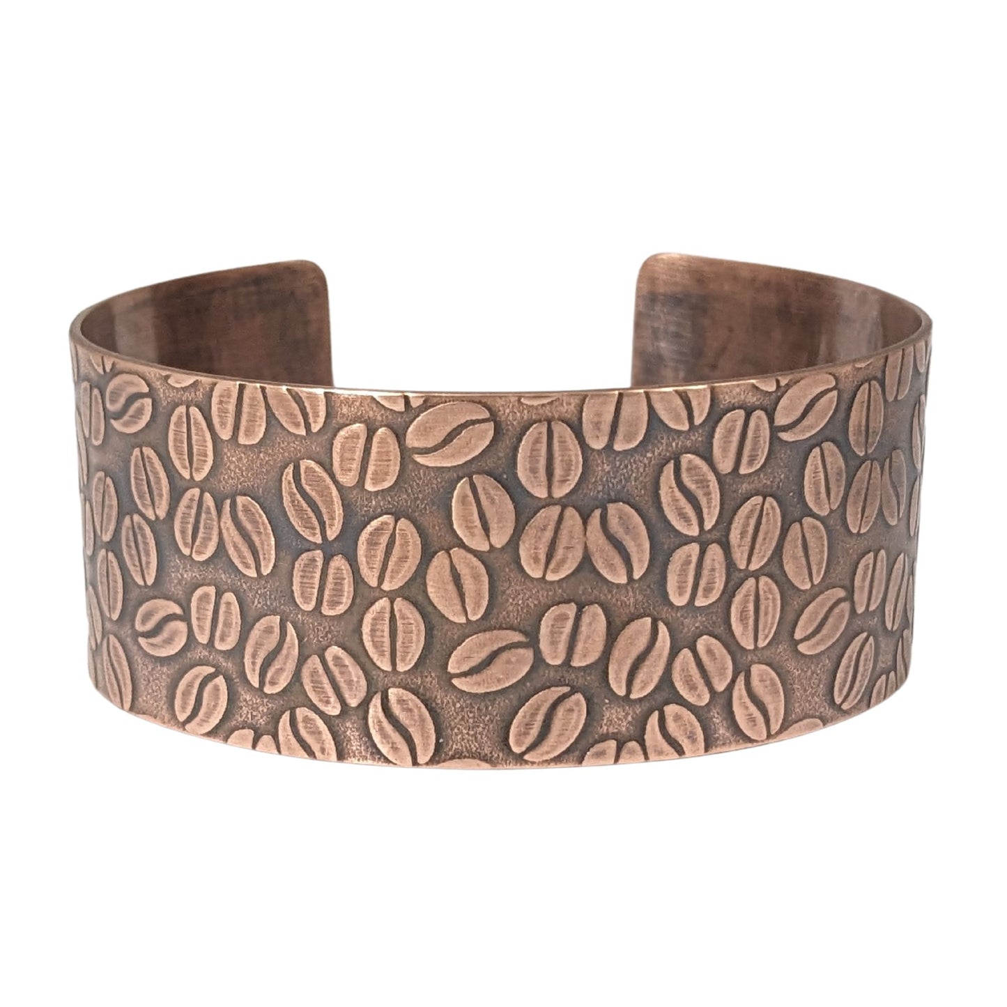 Copper cuff bracelet covered with impressed design of coffee beans.