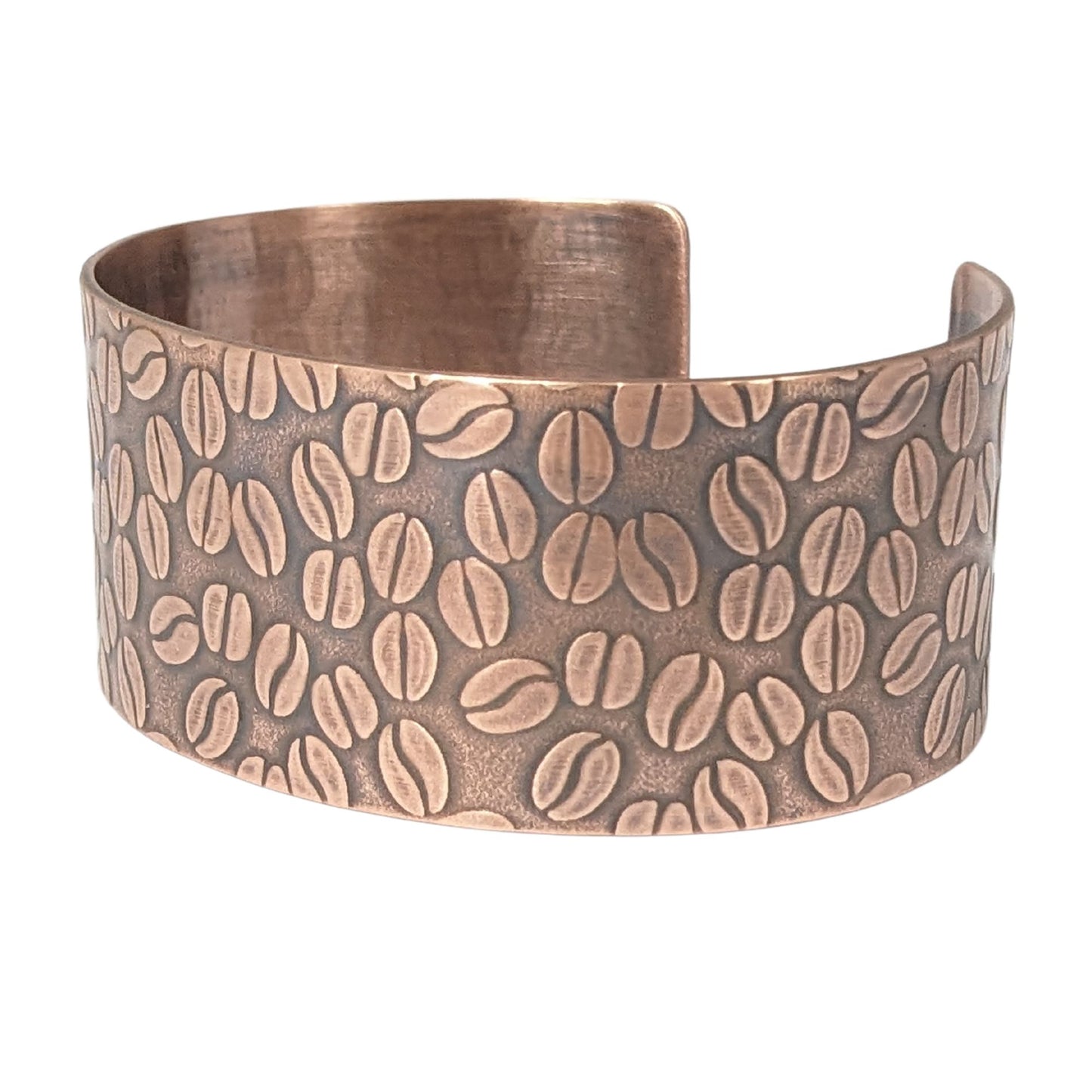 Copper cuff bracelet covered with impressed design of coffee beans.