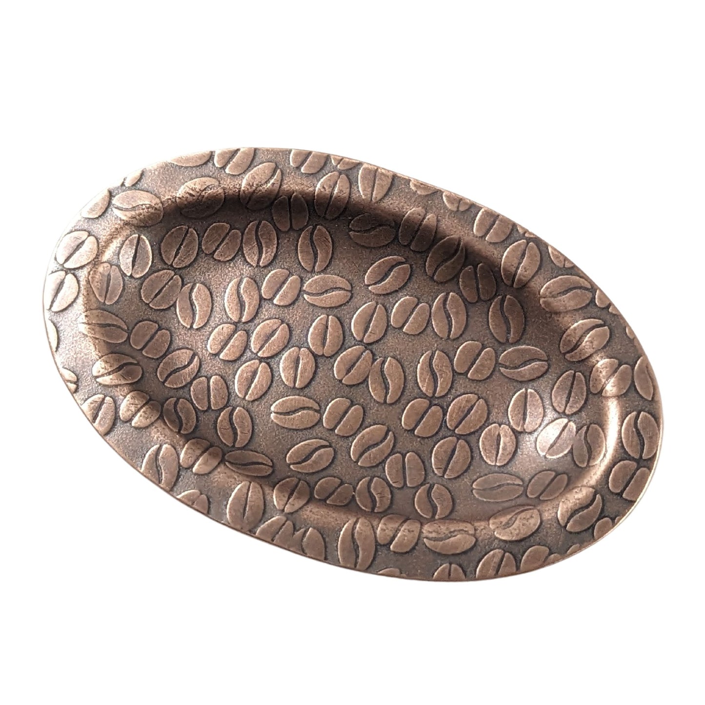 An oval copper ring dish with a raised edge. The dish has an impressed pattern of coffee beans.