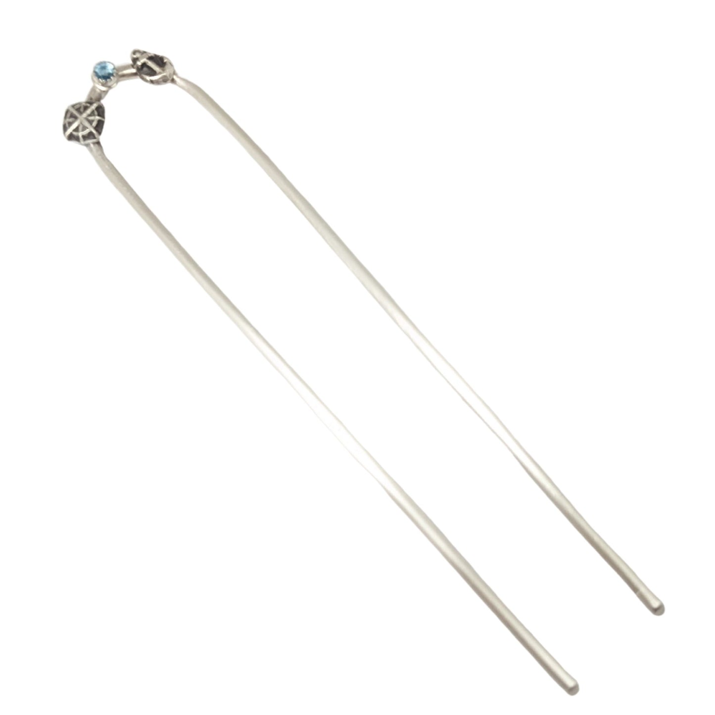 Sterling silver hair fork with three small design elements. Left is a silver compass rose, center is a rose cut blue topaz gemstone, right is a silver anchor