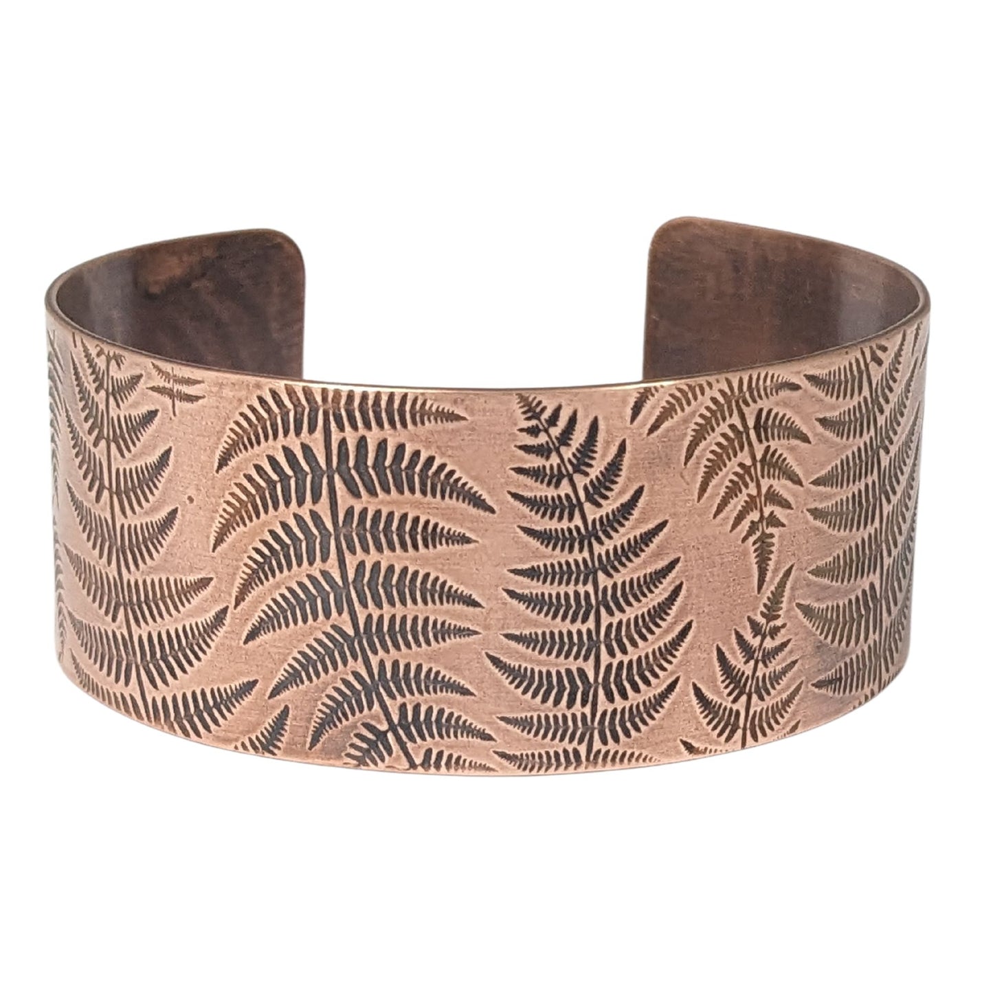 copper cuff bracelet covered in impressions of fern fronds.