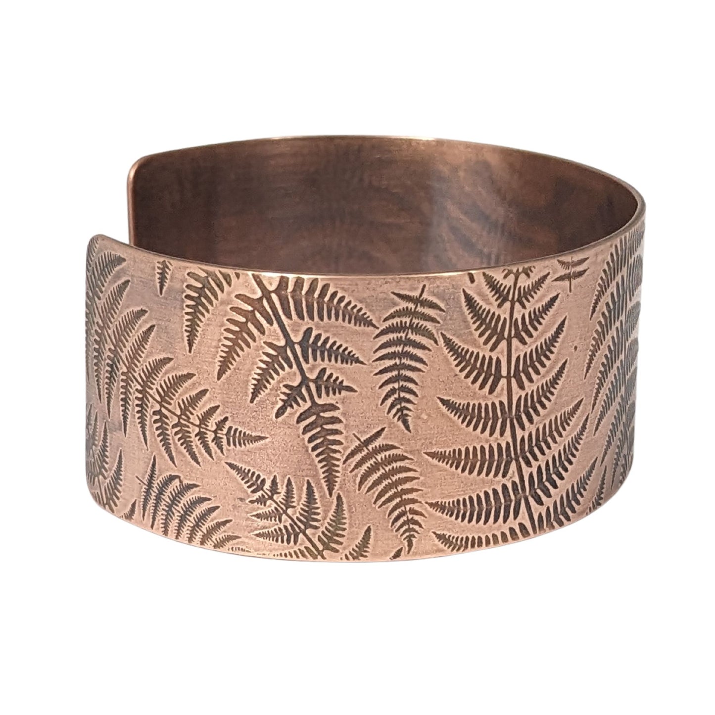 copper cuff bracelet covered in impressions of fern fronds.