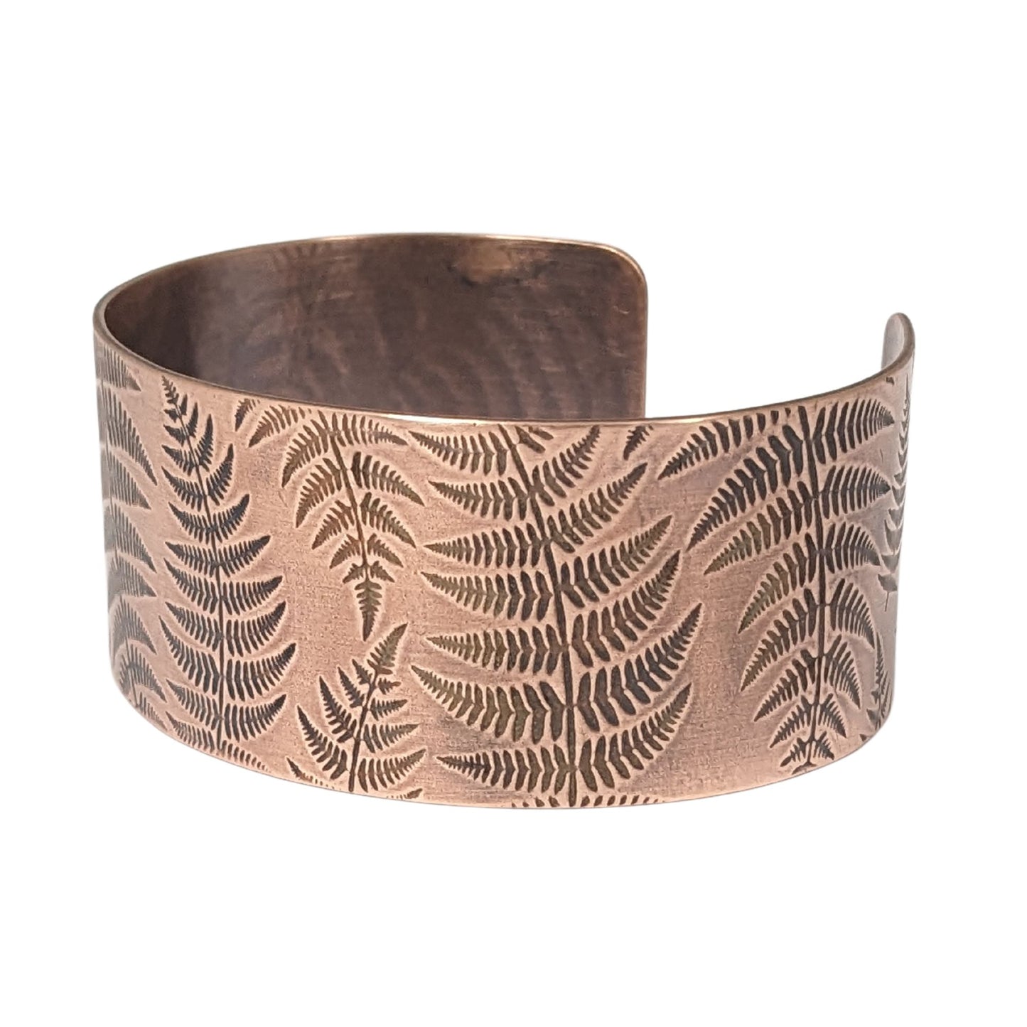 copper cuff bracelet covered in impressions of fern fronds.