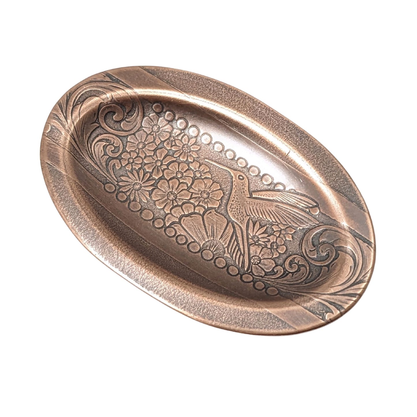 val copper ring dish with a raised lip. Pattern across middle is a hummingbird surronded by flowers. The edge of the pattern is a scrolled leaf resembling ferns.