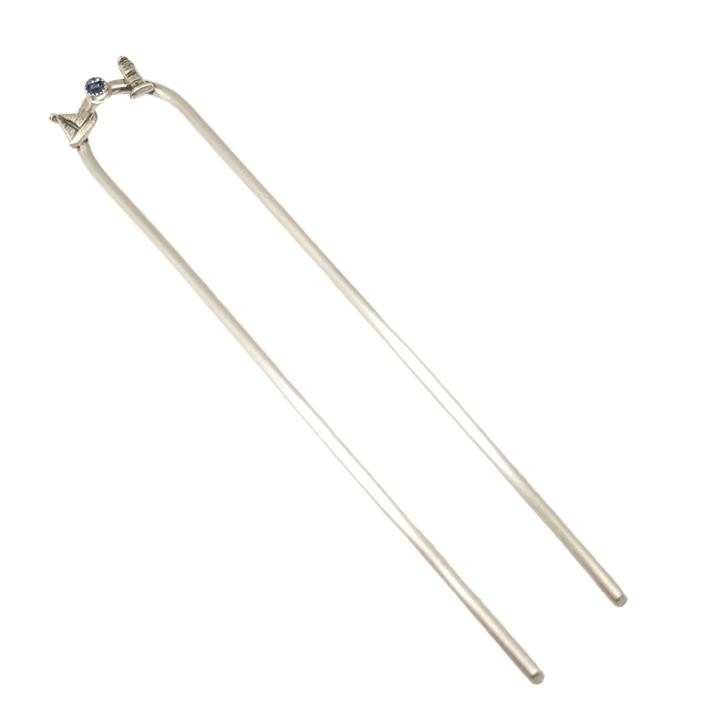 Sterling silver hair fork with three small design elements. Left is a silver sailboat, center is a rose cut blue topaz gemstone, right is a silver lighthouse