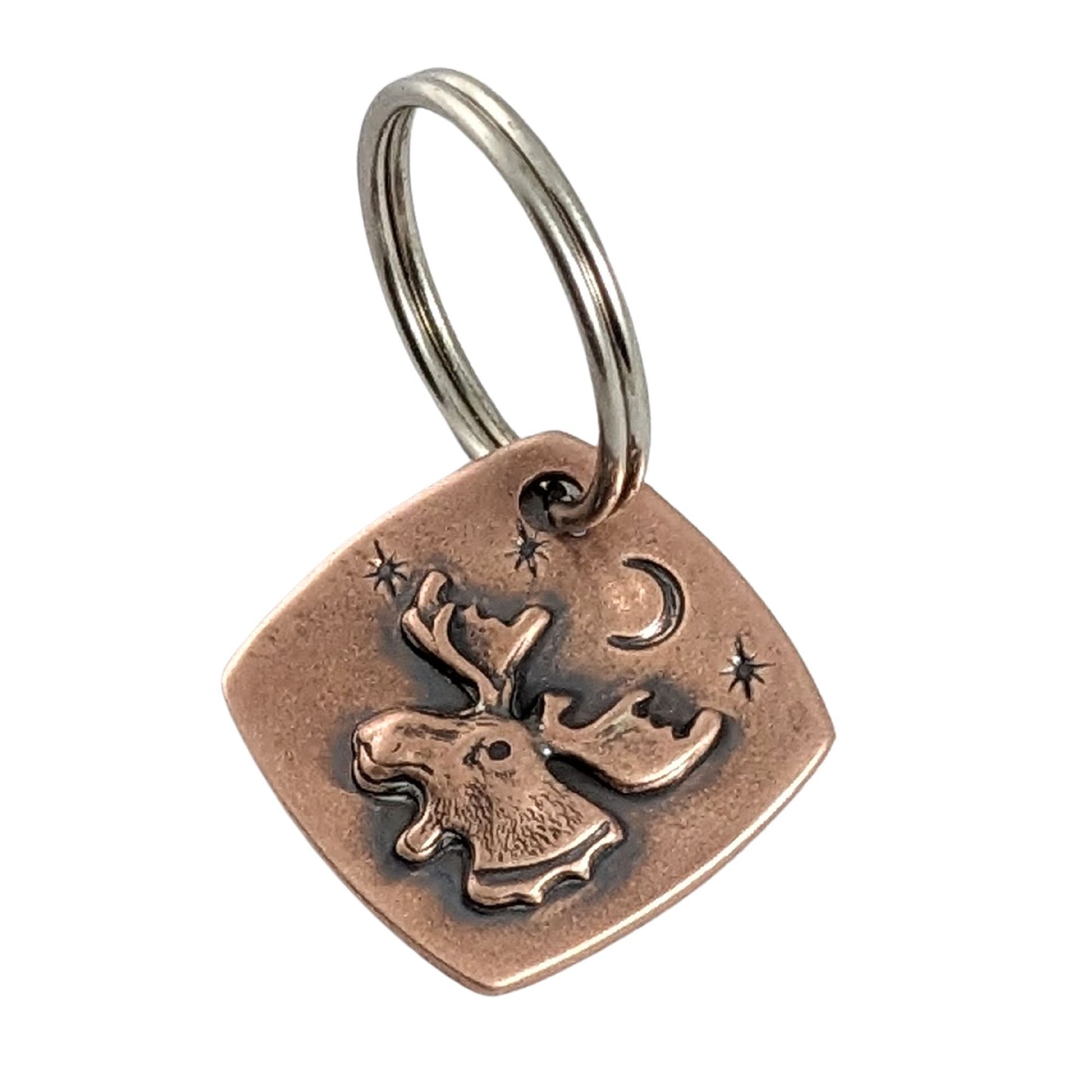 square copper keychain with raised moose head, background is a moon and stars