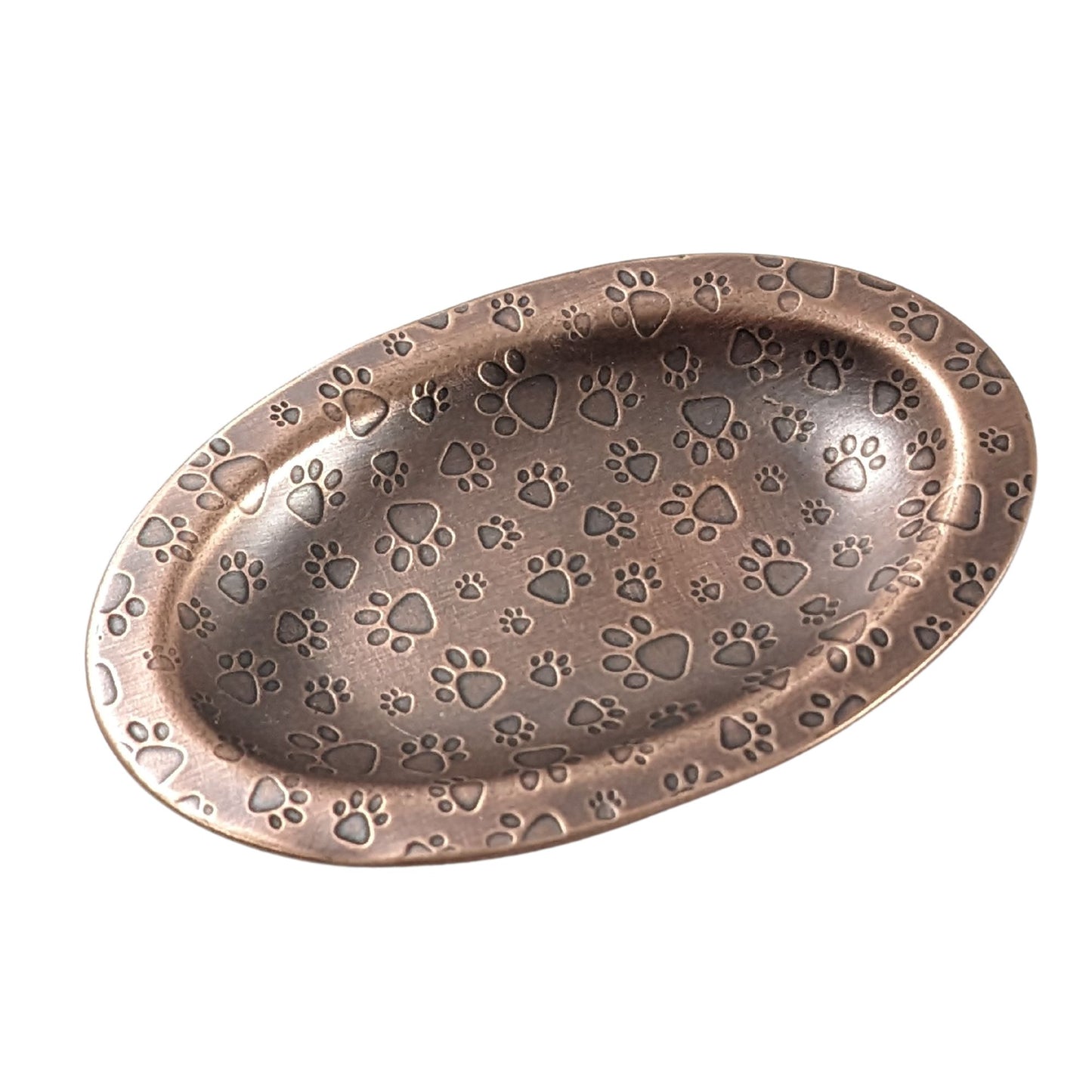 An oval copper ring dish with a raised edge. The dish has an impressed pattern of dog paw prints.