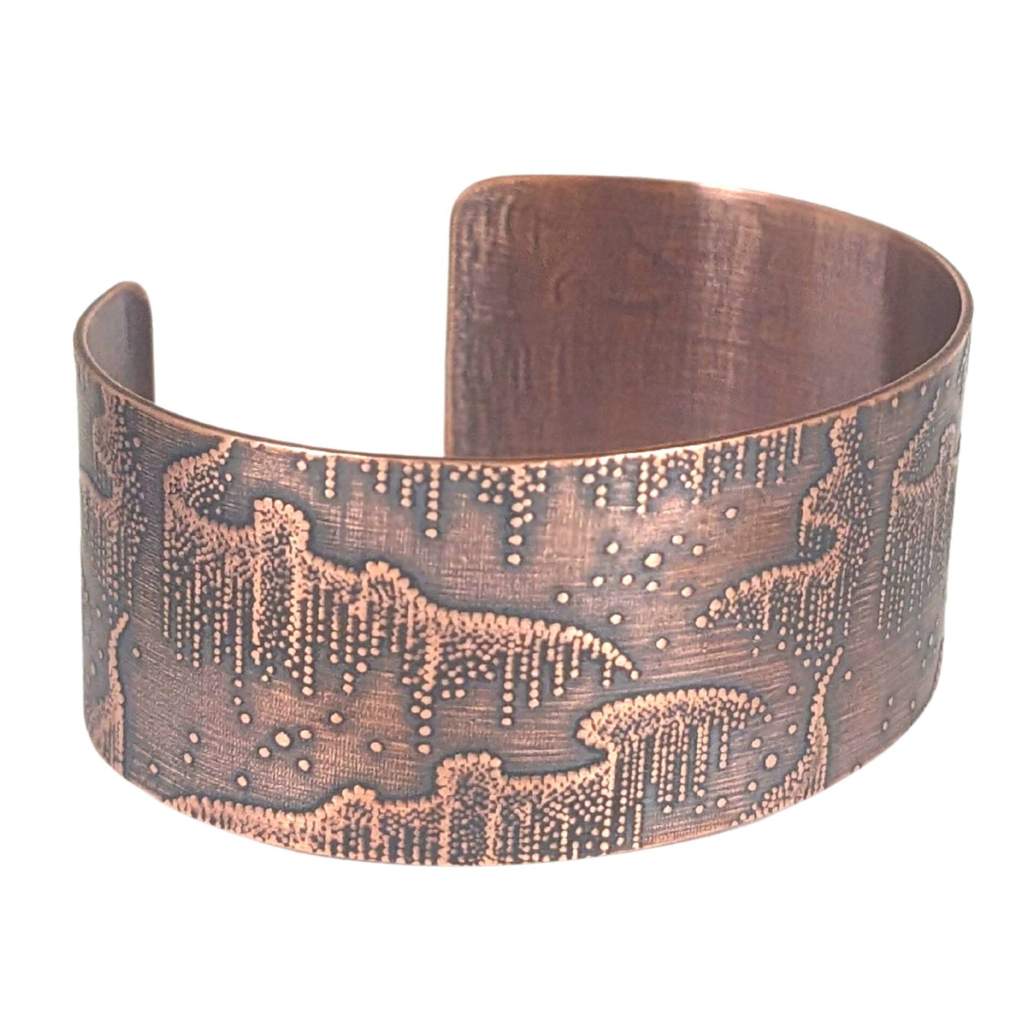 Wide copper cuff bracelet with repeated design pattern representing the aurora borealis
