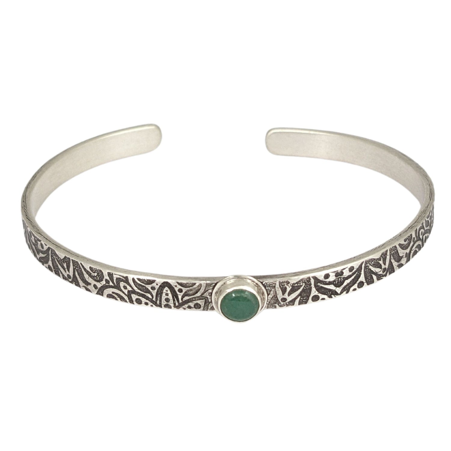 Narrow sterling silver cuff bracelet with a green aventurine gemstone. The rectangular silver wire has a n abstract impressed design, and the impression is oxidized black to bring out the details.