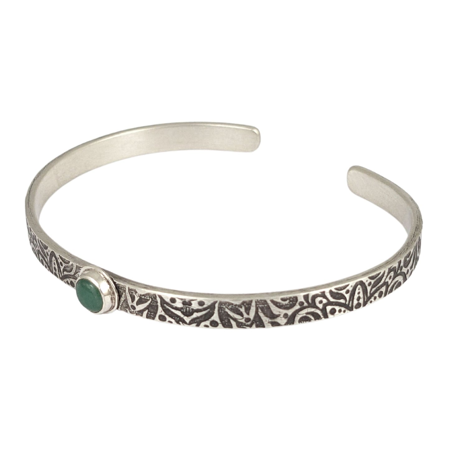 Narrow sterling silver cuff bracelet with a green aventurine gemstone. The rectangular silver wire has a n abstract impressed design, and the impression is oxidized black to bring out the details.