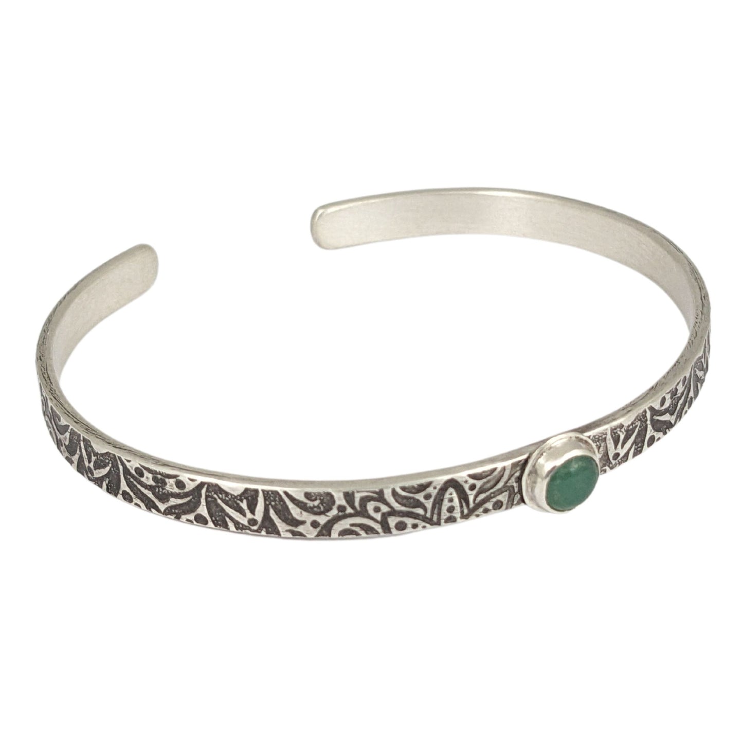 Narrow sterling silver cuff bracelet with a green aventurine gemstone. The rectangular silver wire has a n abstract impressed design, and the impression is oxidized black to bring out the details.