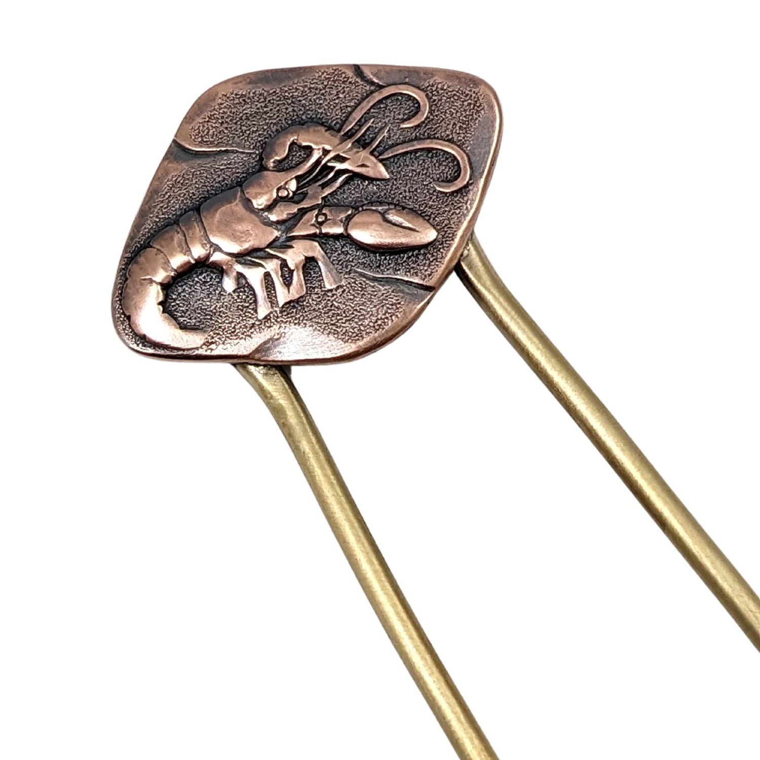 Lobster hair fork. The lobster design is an impression on a rectangular shaped piece of copper. The fork is brass.
