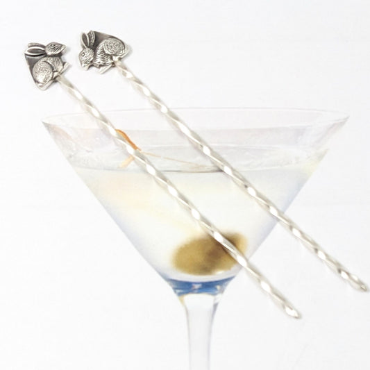 Sterling silver cocktail picks with silver rabbits on top. One rabbit faces left, the other faces right.
