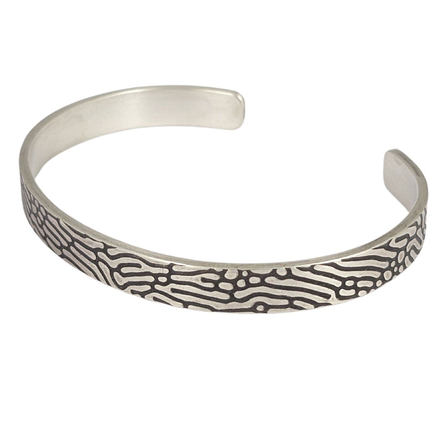 Rectangular shaped sterling silver wire cuff bracelet with an impressed design that looks like Brain Coral. The impressed design is darkened, so the coral lines are black against the silver.