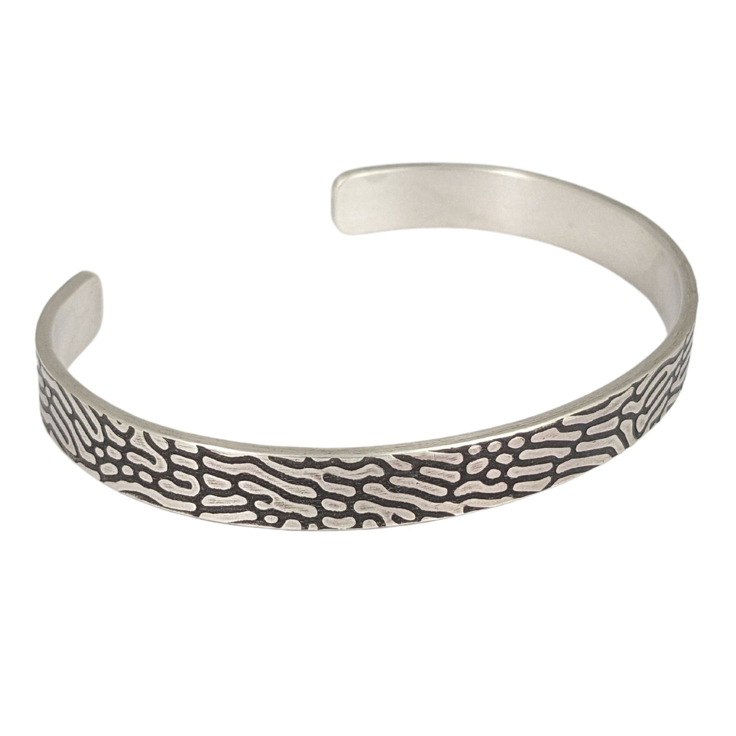 Rectangular shaped sterling silver wire cuff bracelet with an impressed design that looks like Brain Coral. The impressed design is darkened, so the coral lines are black against the silver.