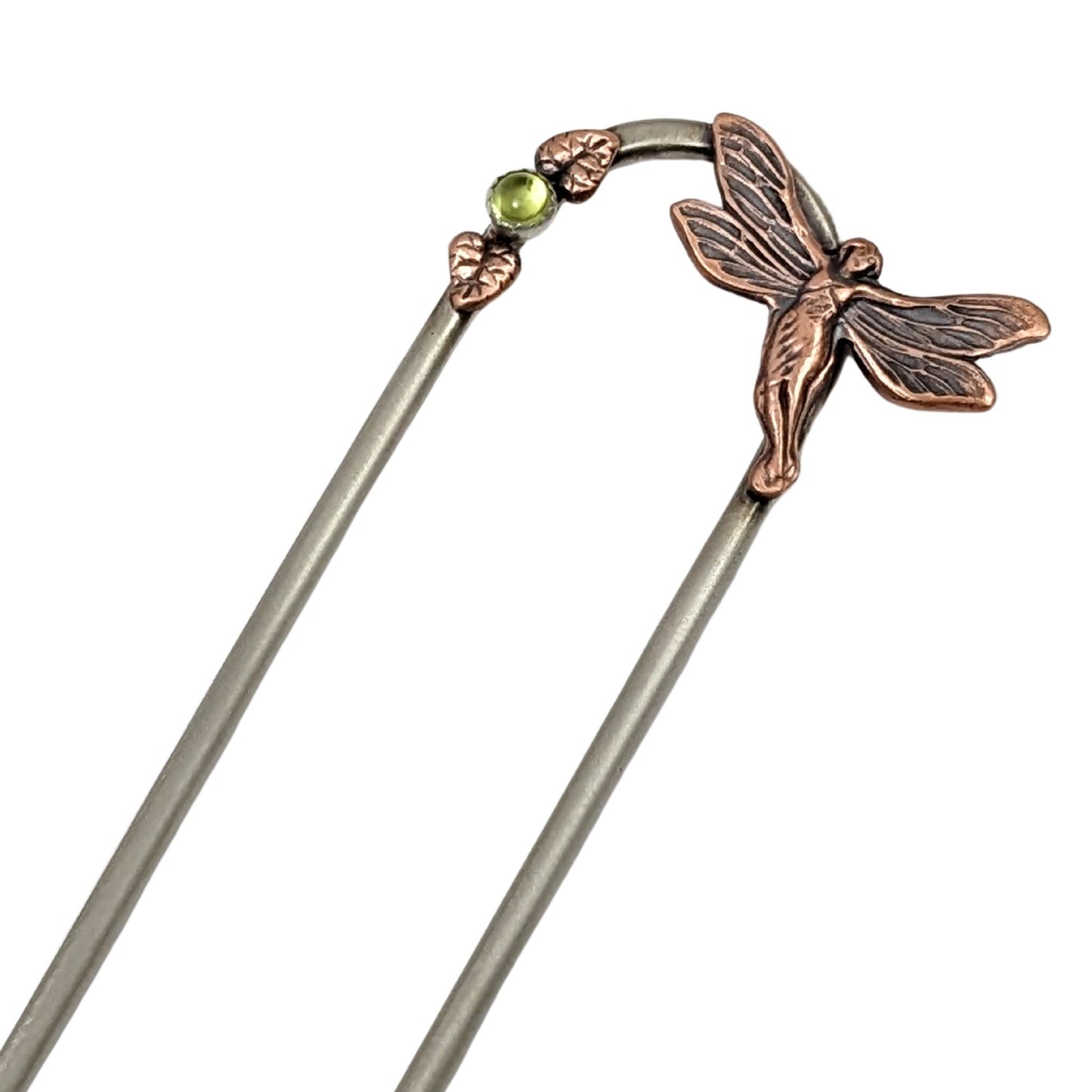 Fairy Hair Fork. At top left side there is a three dimension fairy with her wings spread. On the left side is a green peridot gemstone with one copper leaf above the stone and one below. The fork is nickel.