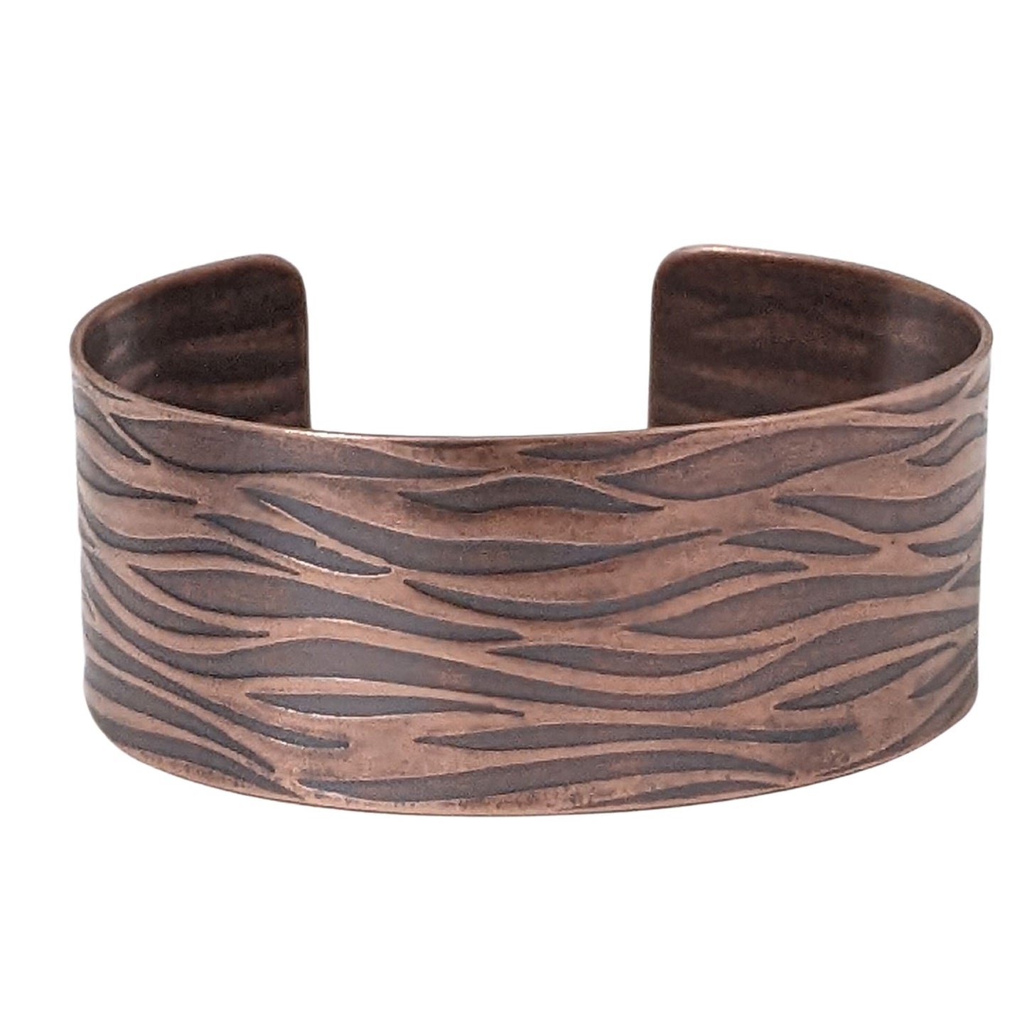 copper cuff bracelet with impressed design that looks like gently rippling water surface