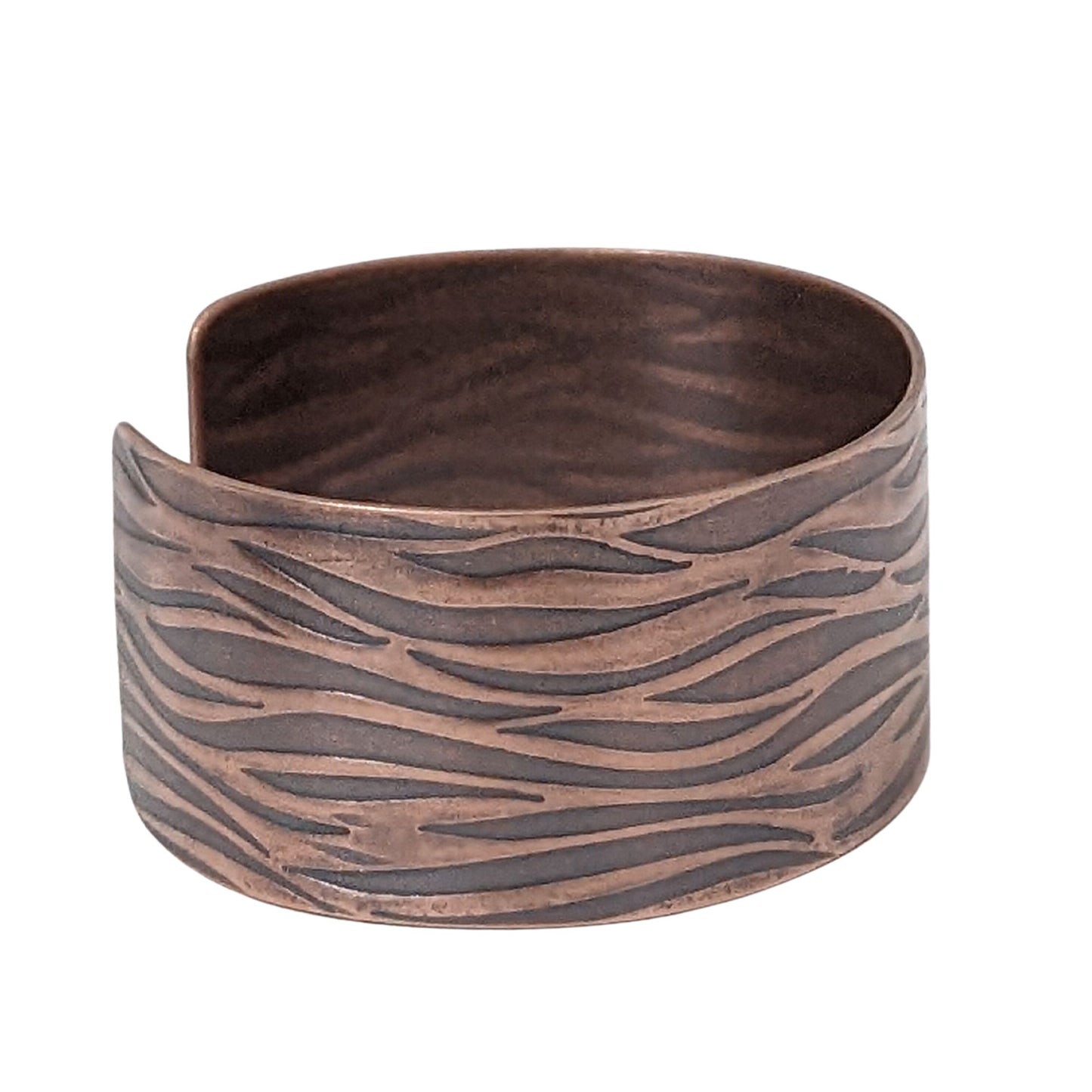 copper cuff bracelet with impressed design that looks like gently rippling water surface