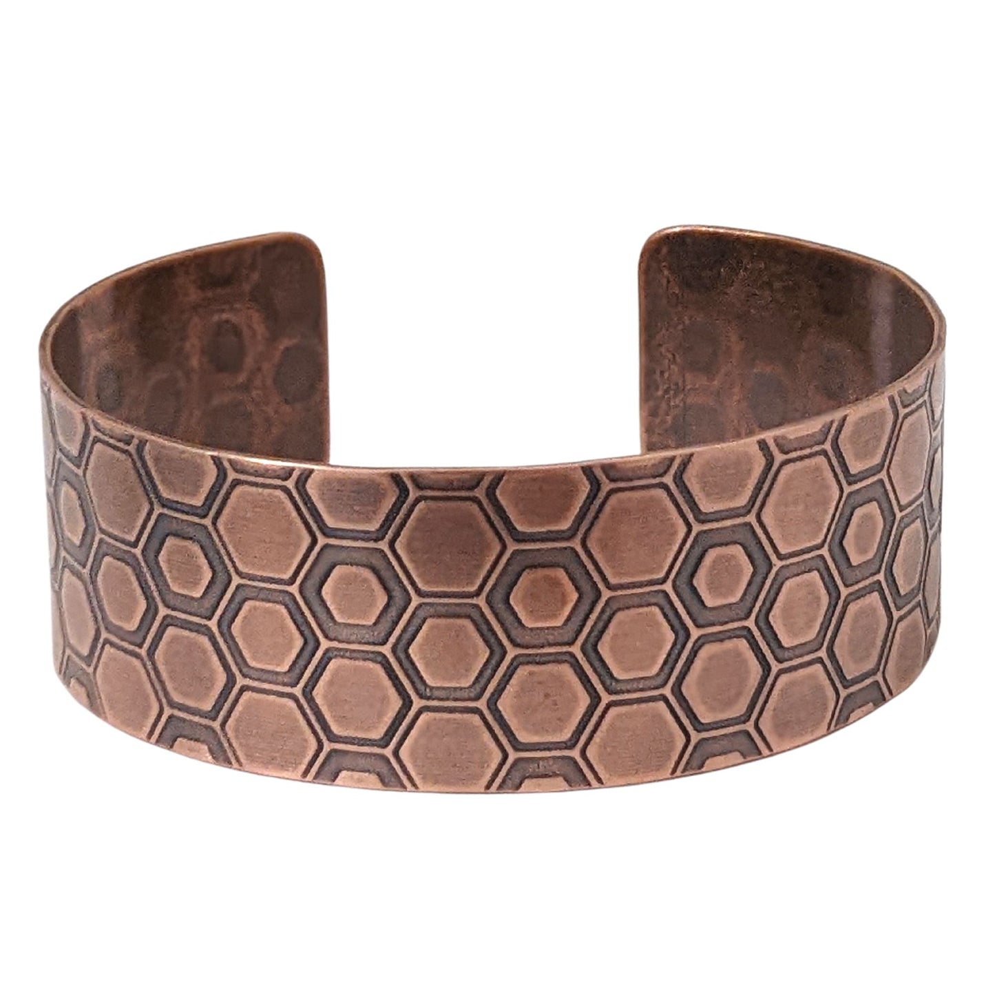 One inch wide copper cuff bracelet with a honeycomb pattern. Each vertical row of combs has a little over 3  combs. The comb edges are impressed into the copper and darkened to bring out the detail.