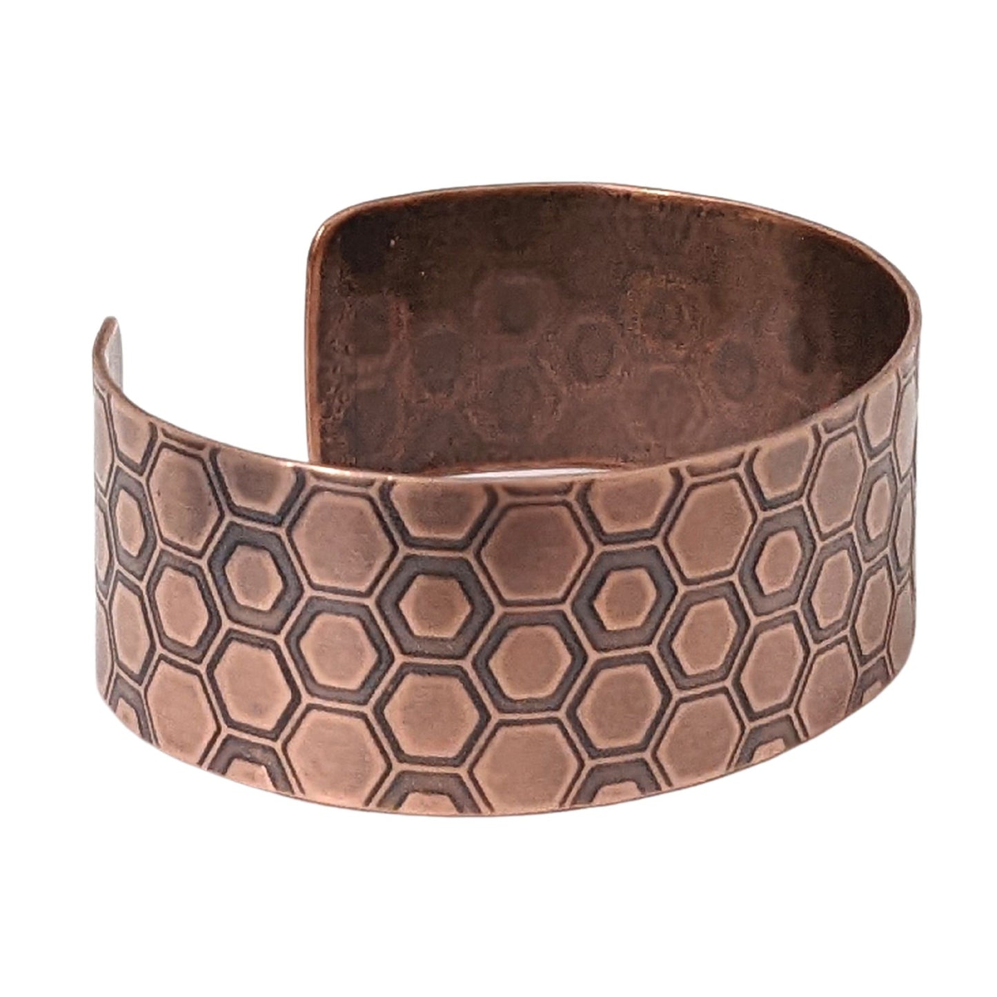 One inch wide copper cuff bracelet with a honeycomb pattern. Each vertical row of combs has a little over 3  combs. The comb edges are impressed into the copper and darkened to bring out the detail.