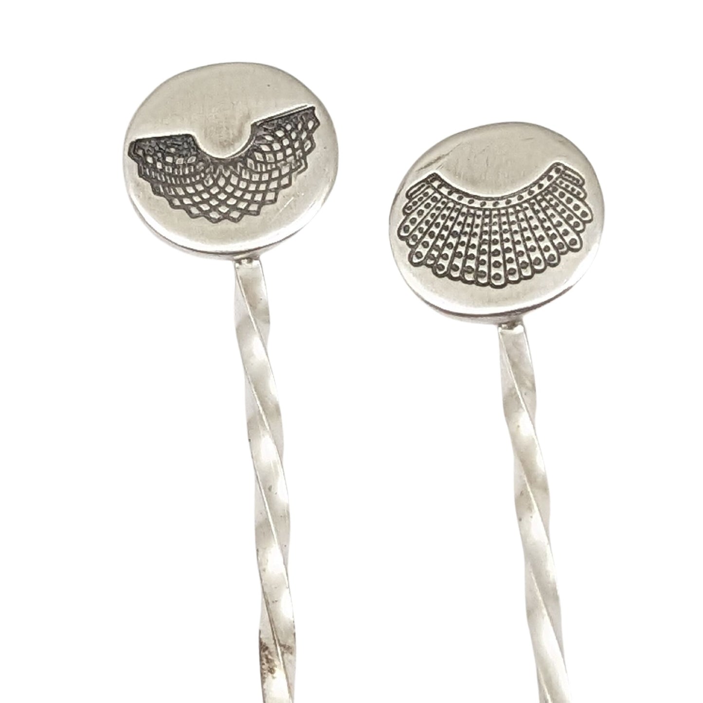 Sterling silver cocktail pick with decorative element on top. One has a round disc with stamping of RBGs Favorite collar, the other of RGB's Dissent Collar