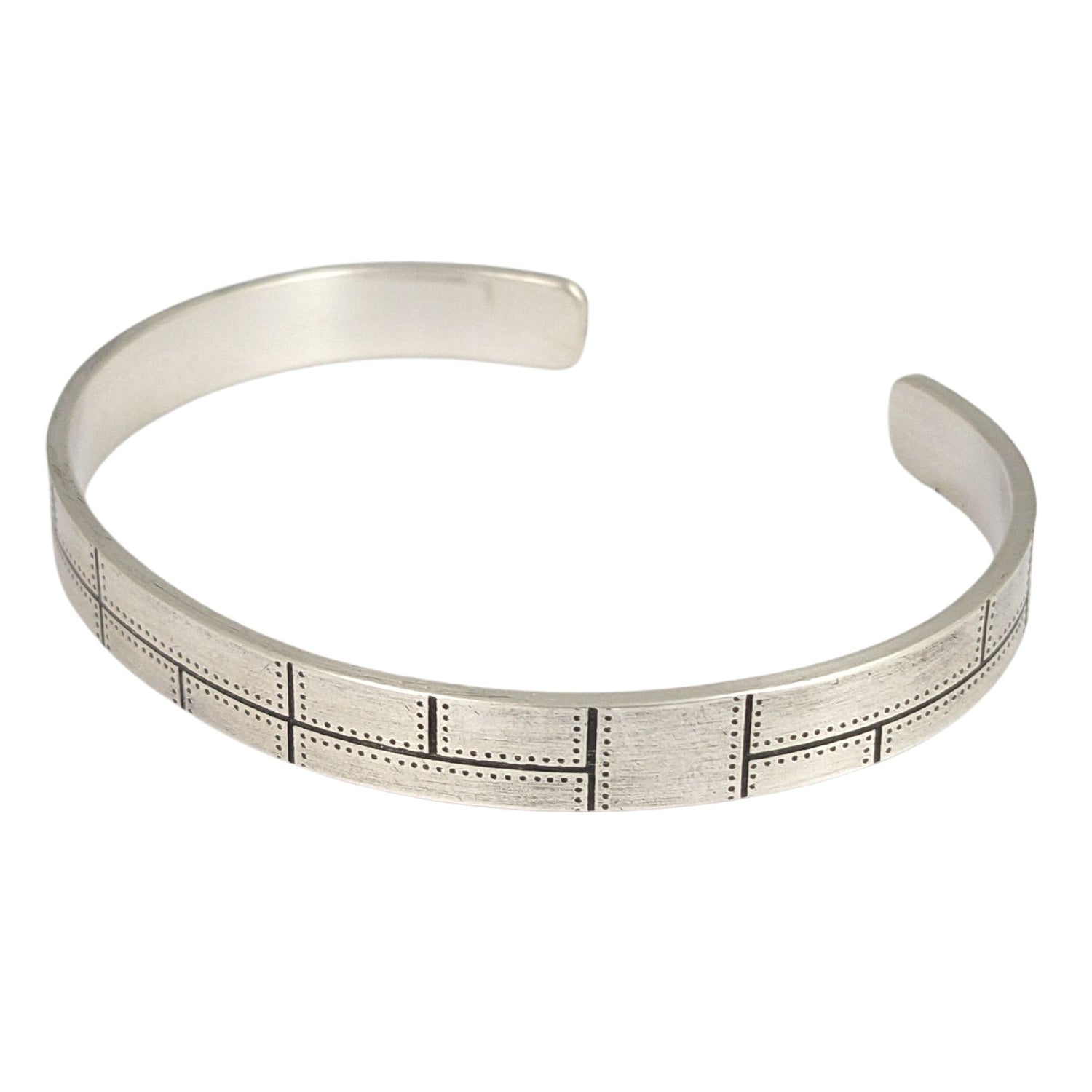 Rectangular sterling silver cuff with a riveted panel pattern. 
