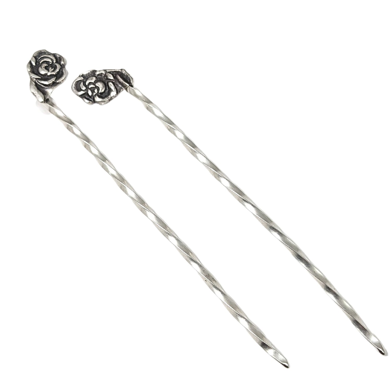 Pair of sterling silver cocktail picks, each with a rose on top.