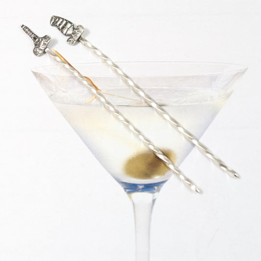 Pair of sterling silver cocktail picks. One has a lighthouse on top, the other has a tall ship.