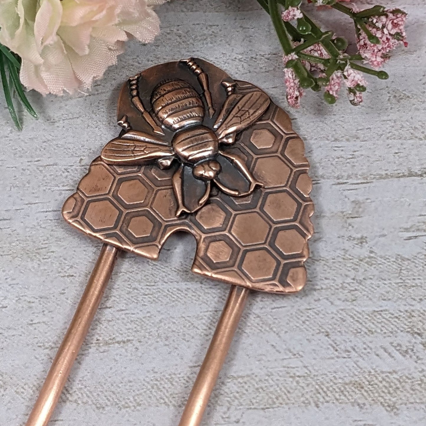 Copper Hair Fork with Bee and Beehive. The large beehive has a honeycomb design and the bee is very detailed and large enough to cover most of the hive. Recessed areas are darkened to highlight the details.