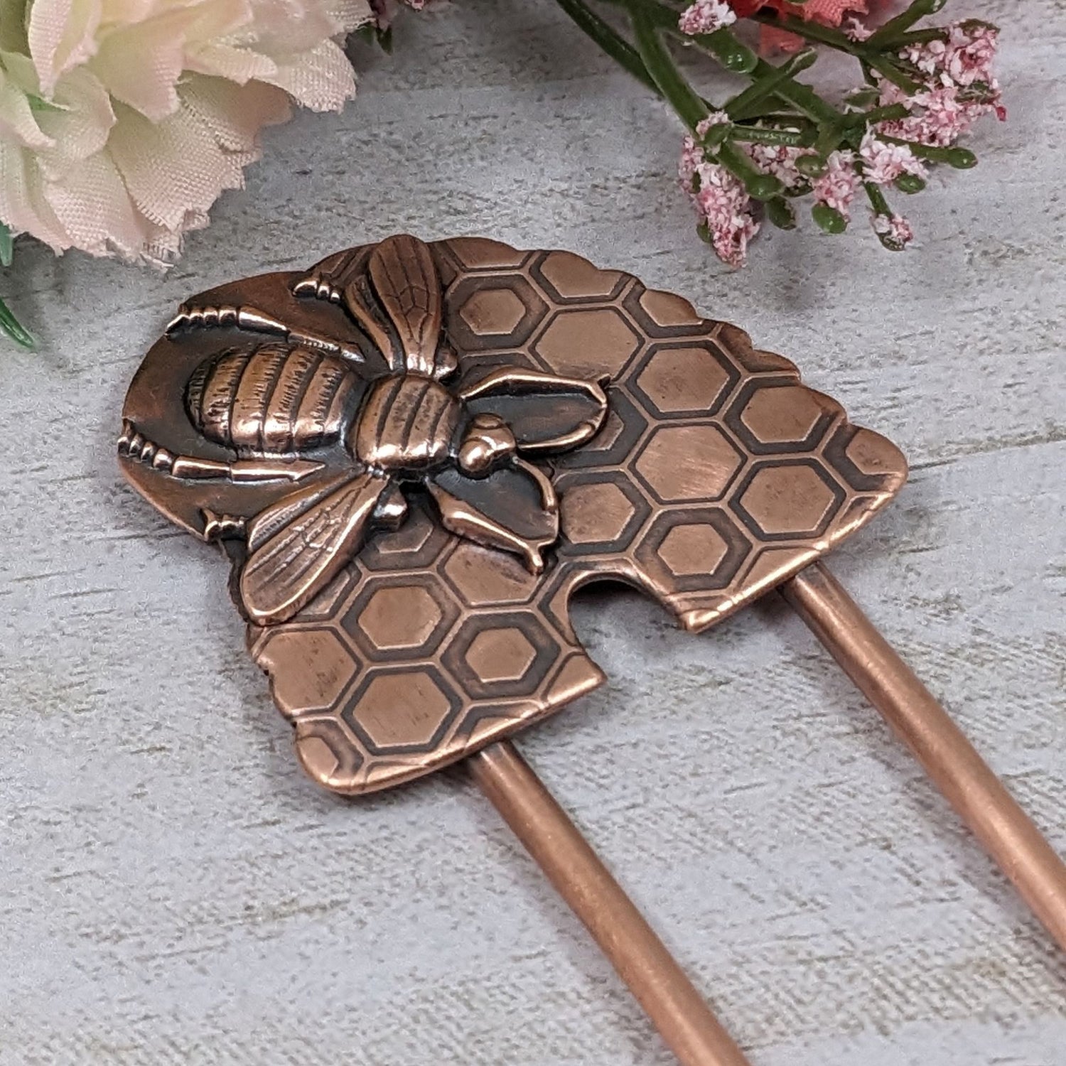 Copper Hair Fork with Bee and Beehive. The large beehive has a honeycomb design and the bee is very detailed and large enough to cover most of the hive. Recessed areas are darkened to highlight the details.