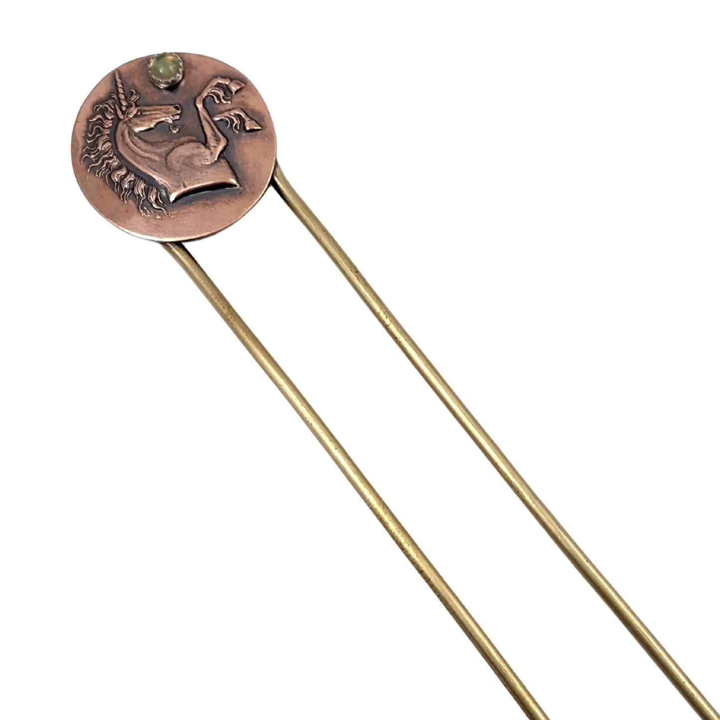 Brass hair fork with a copper design at the top. The copper is round with a raised impression of a unicorn. You can see the beard, detailed hair in the mane and on the ankles. The horn is spiraled. Above the nose there is a round gemstone meant to represent the moon.