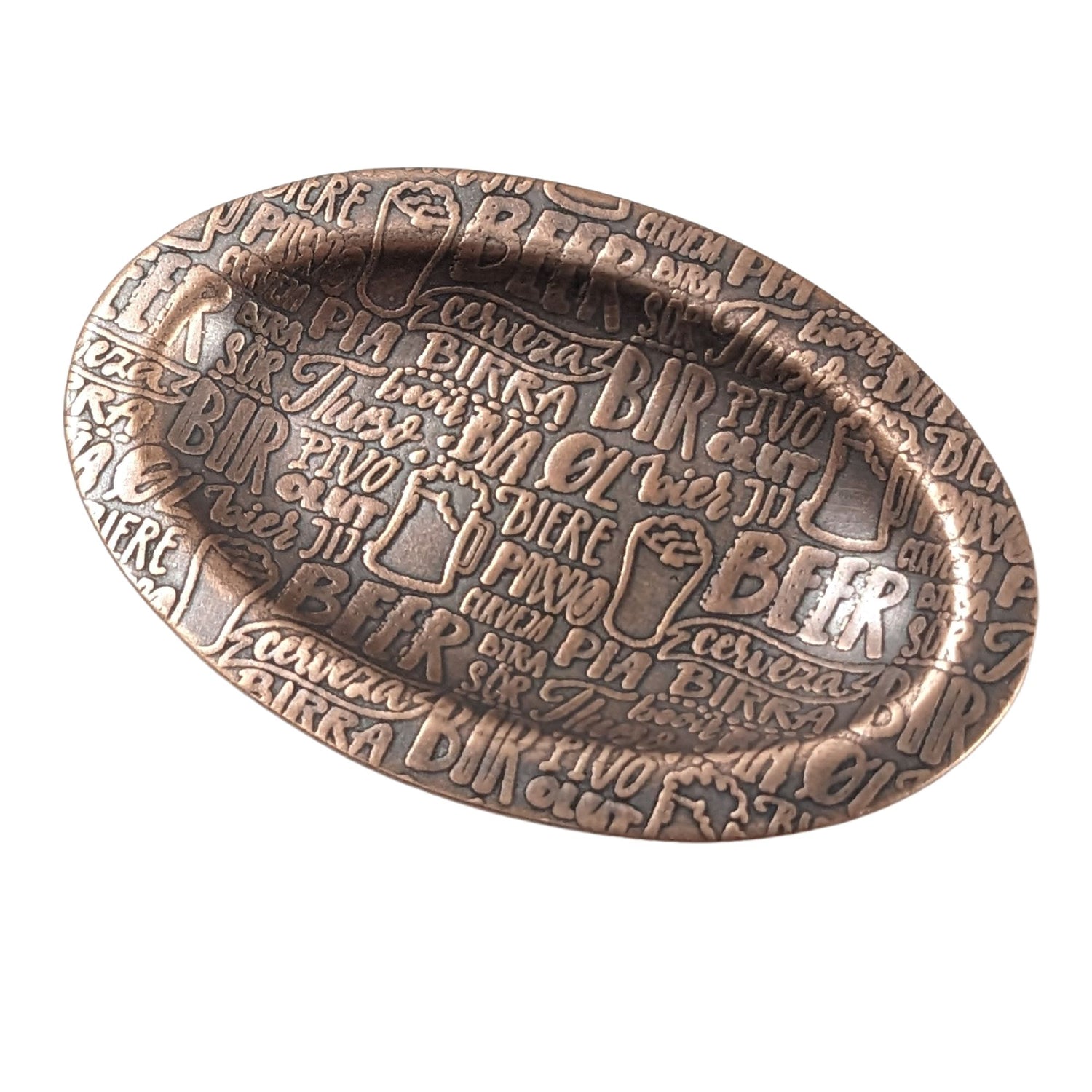 An oval copper ring dish with a raised edge. The dish has an impressed pattern made up of the word beer in many languages.