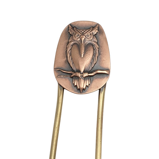 Brass hair fork with copper design element at top. The copper has a raised image of an owl resting on a branch.