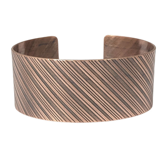 copper cuff bracelet with diagonal stripes like found on candy canes