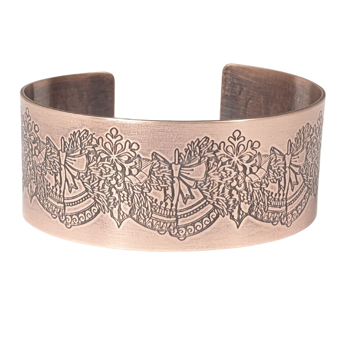copper cuff bracelet. pattern along entire length is an evergreen bough with pairs of bells.
