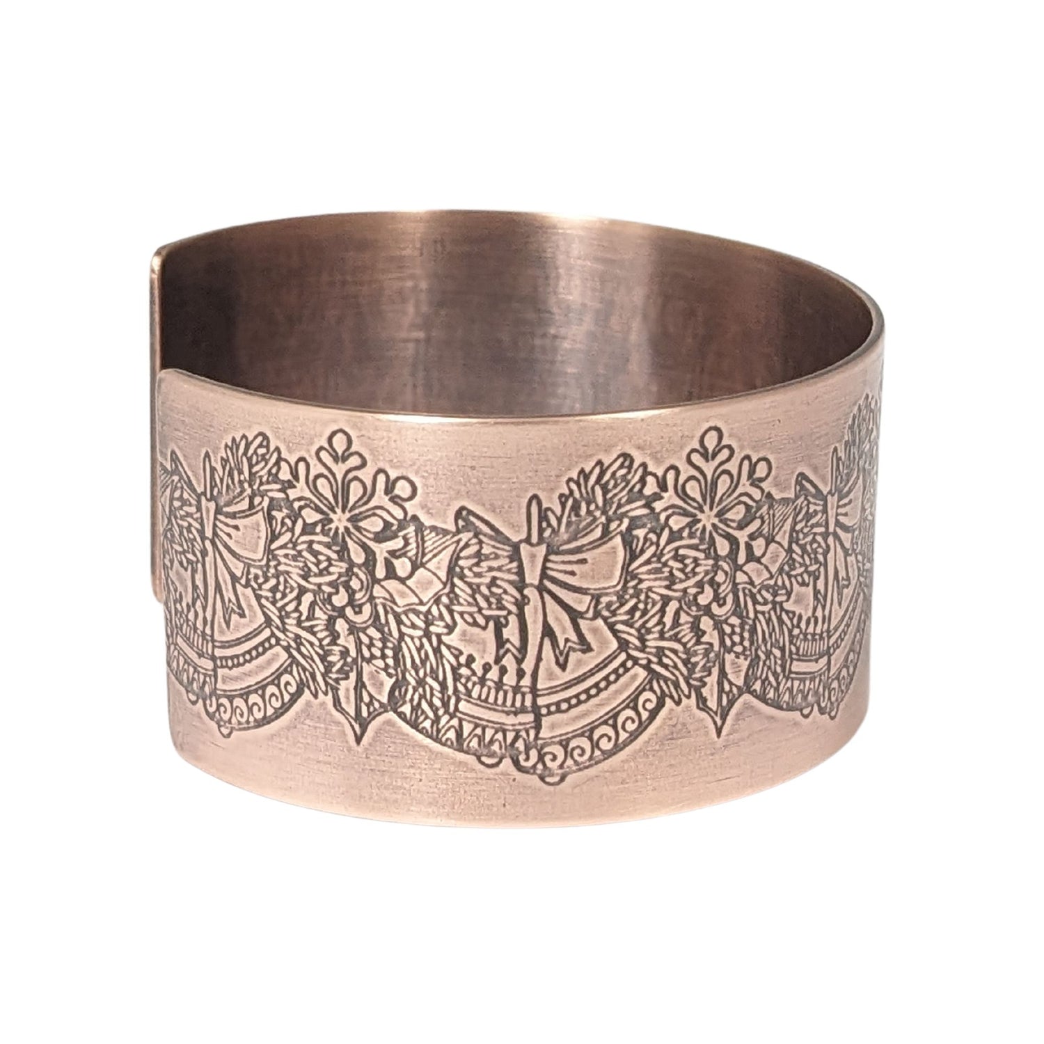 copper cuff bracelet. pattern along entire length is an evergreen bough with pairs of bells.