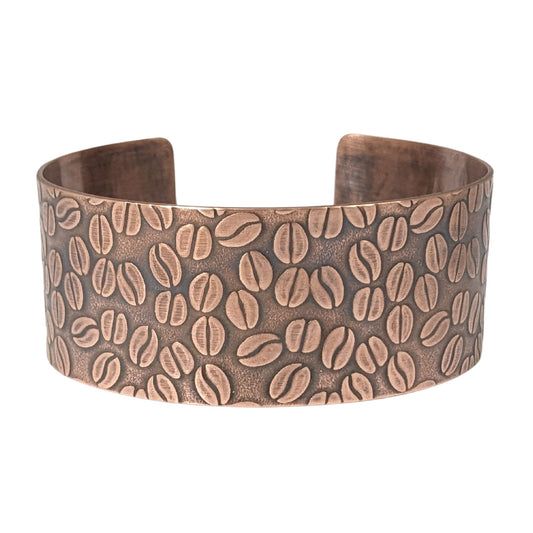 Copper cuff bracelet covered with impressed design of coffee beans.