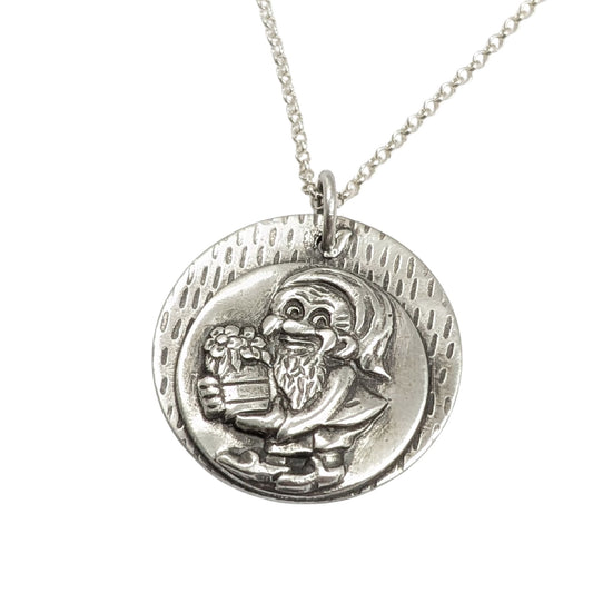 silver pendant with a garden gnome holding a barrel of produce