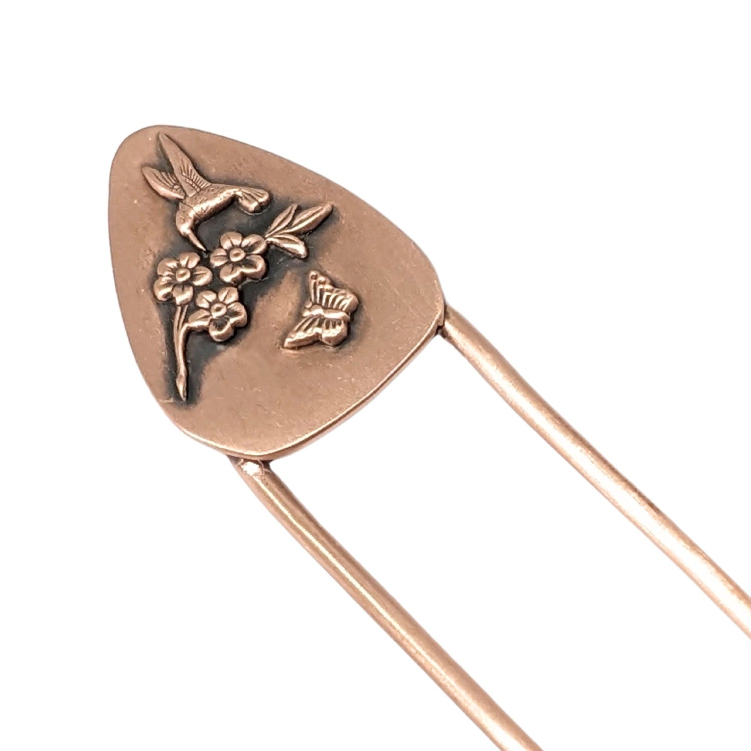 Copper hair fork with a design added to the top. The design is copper and is roughly egg-shaped. On the design are three-dimensional flowers, a hummingbird, and a butterfly.