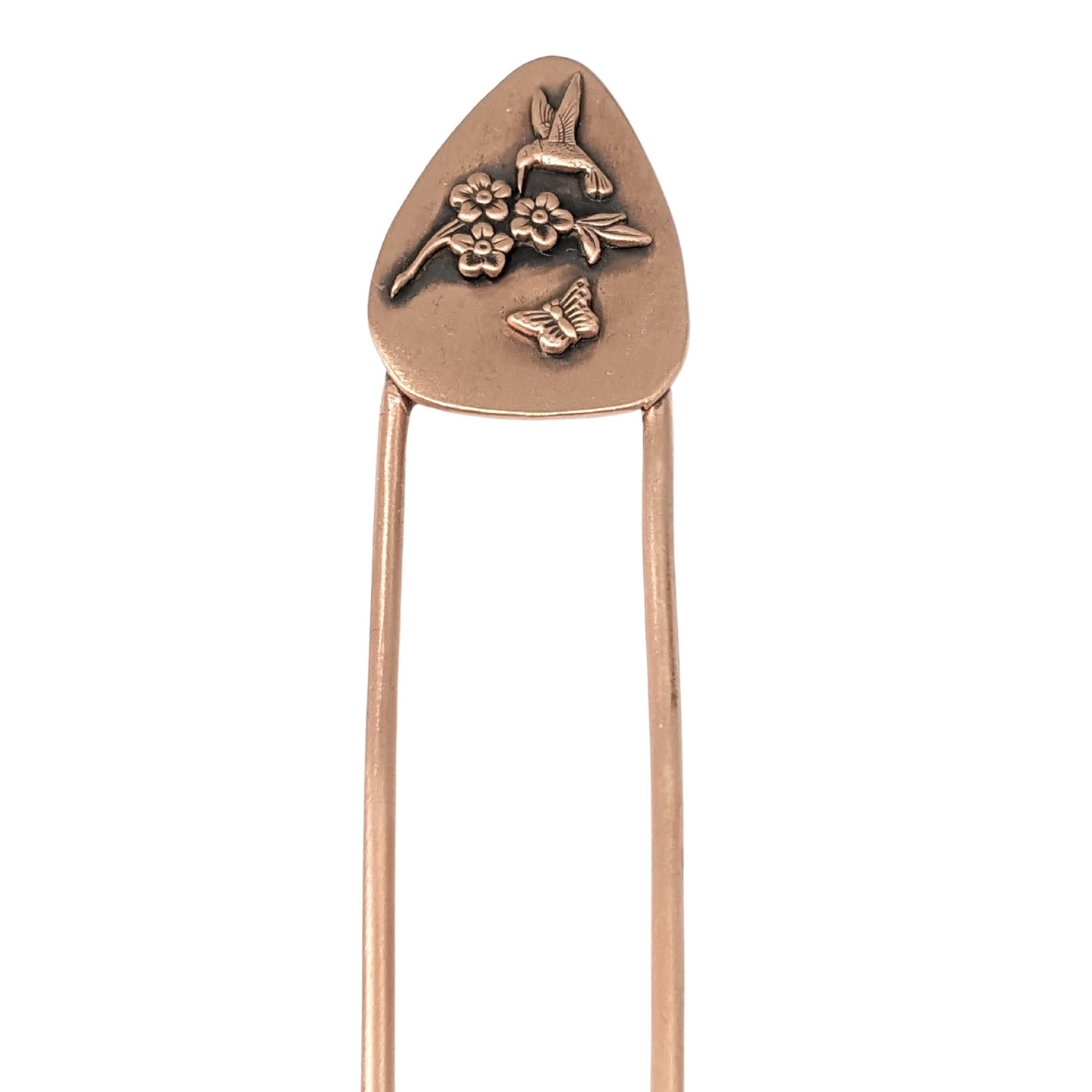 Copper hair fork with a design added to the top. The design is copper and is roughly egg-shaped. On the design are three-dimensional flowers, a hummingbird, and a butterfly.