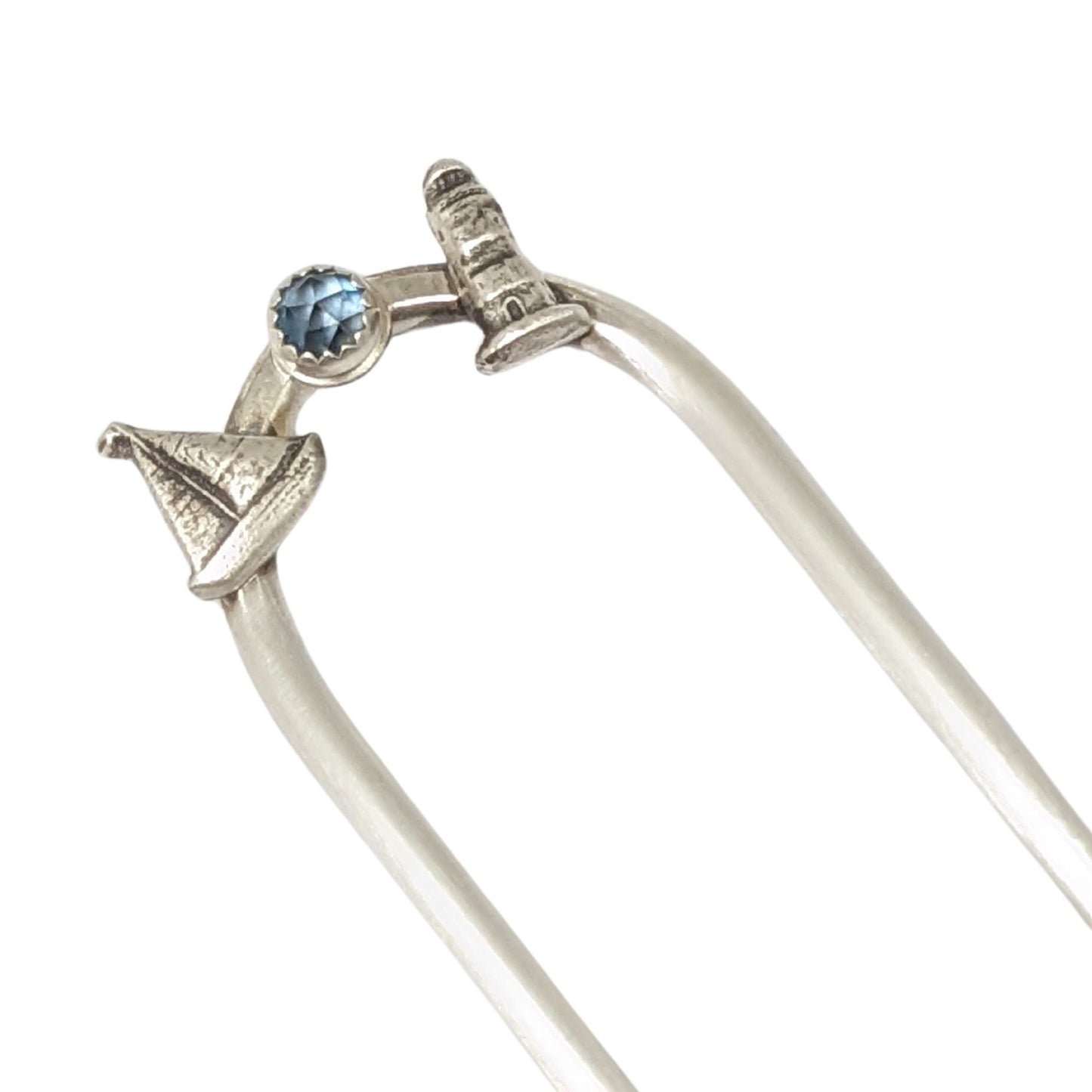 Sterling silver hair fork with three small design elements. Left is a silver sailboat, center is a rose cut blue topaz gemstone, right is a silver lighthouse