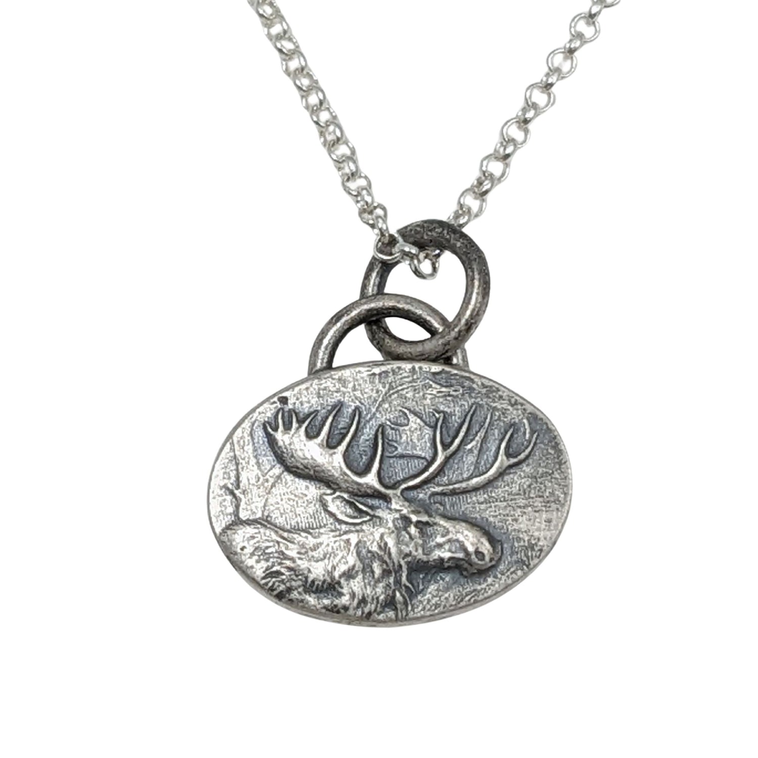 Oval silver pendant with a raised design of a moose, most of the body and all of the head and antlers.