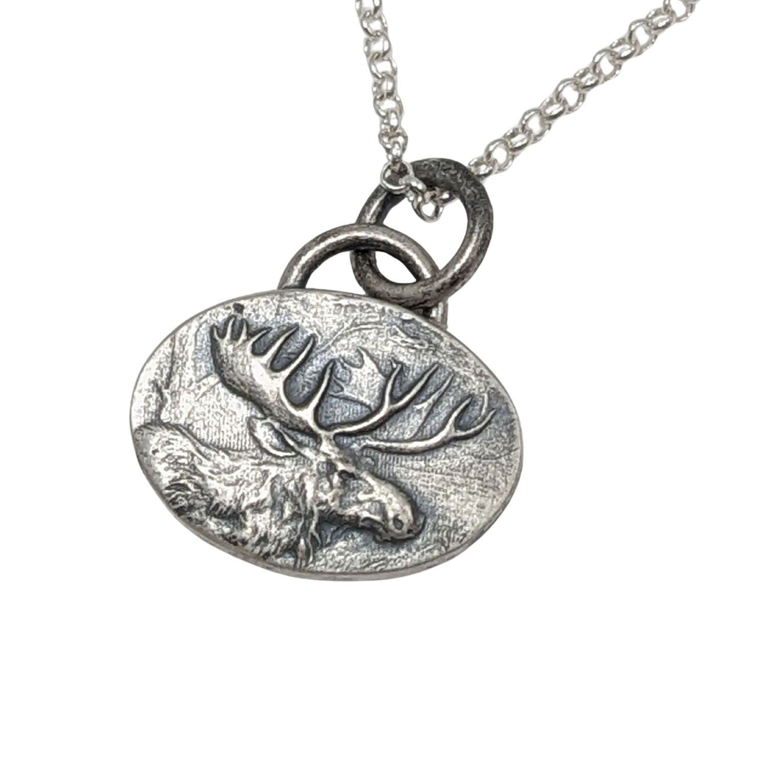 Oval silver pendant with a raised design of a moose, most of the body and all of the head and antlers.