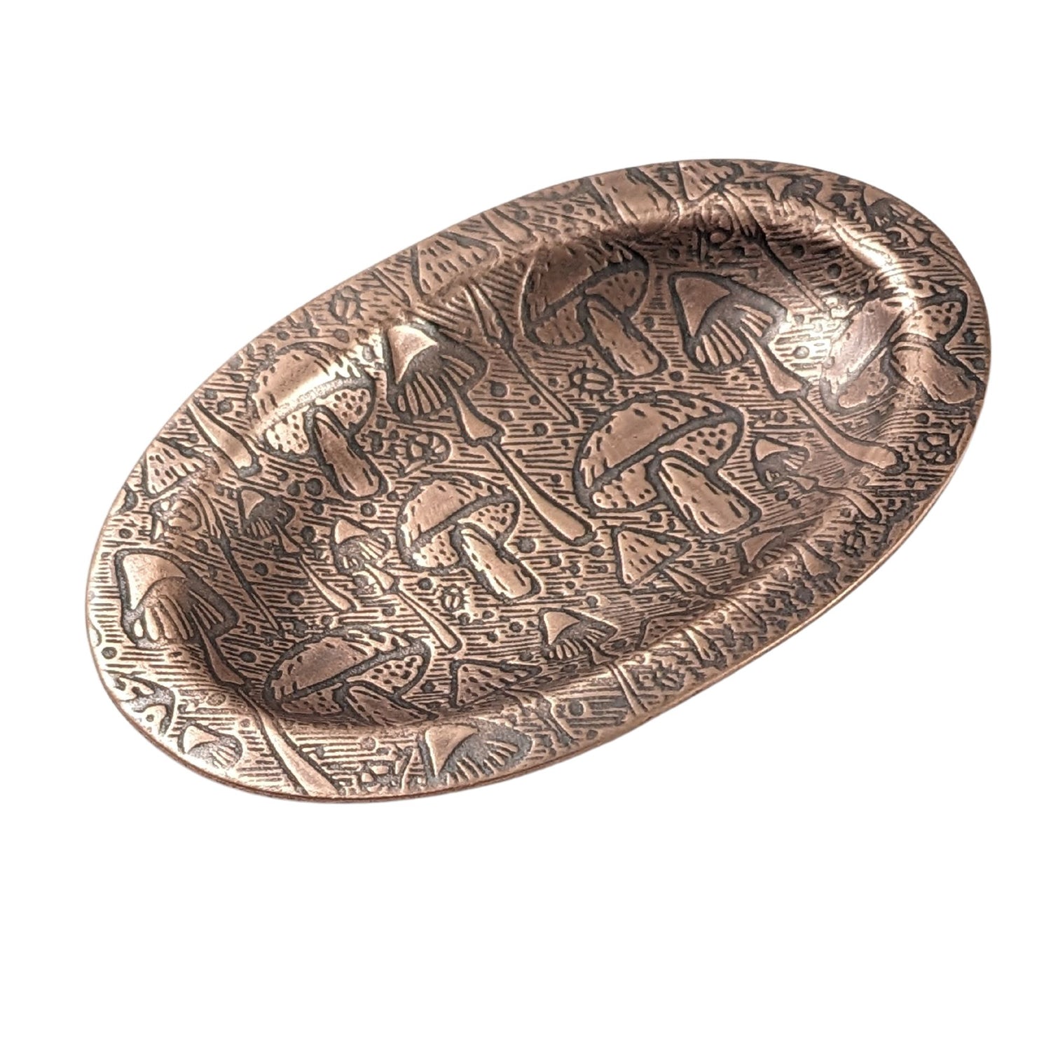 An oval copper ring dish with a raised edge. The dish has an impressed pattern of a variety of mushrooms