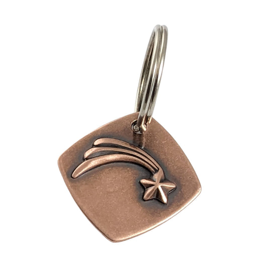 square copper keychain with raised shooting star and three tails